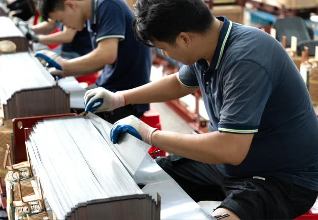 Worker assembling a 37.5 kVA pole mounted transformer during in-house manufacturing and 100% routine testing process